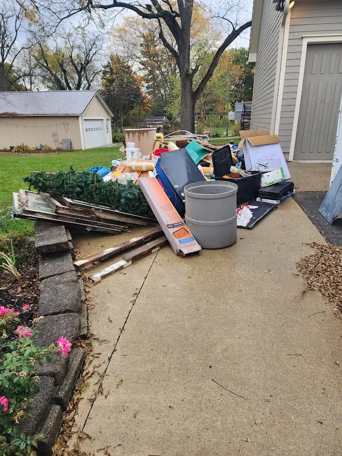 Dumpster being loaded with debris for Estate Cleanout Dumpster Rental in Tontitown